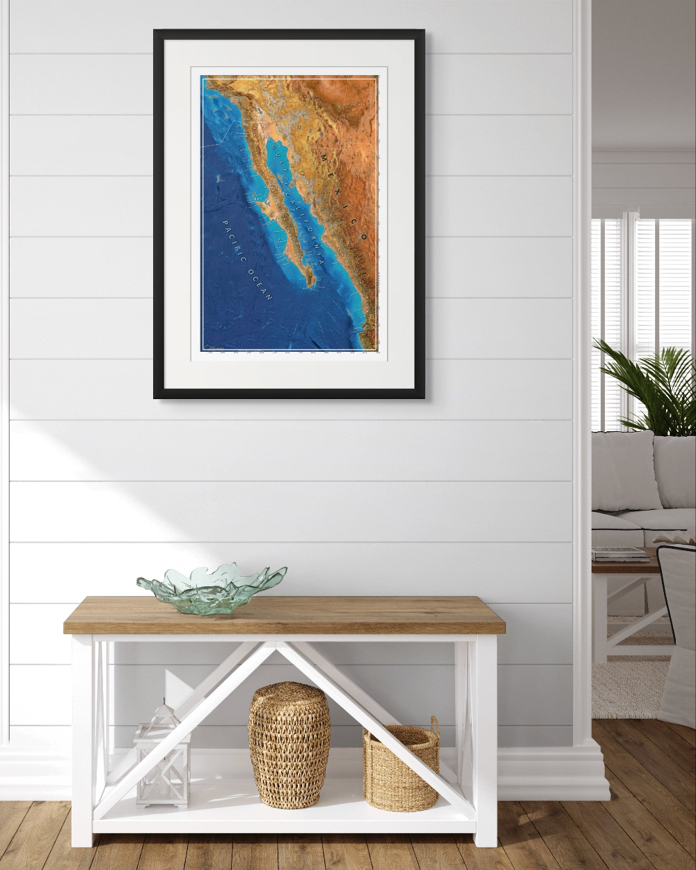 Framed map of Mexico on a wall above a wooden bench with storage baskets.