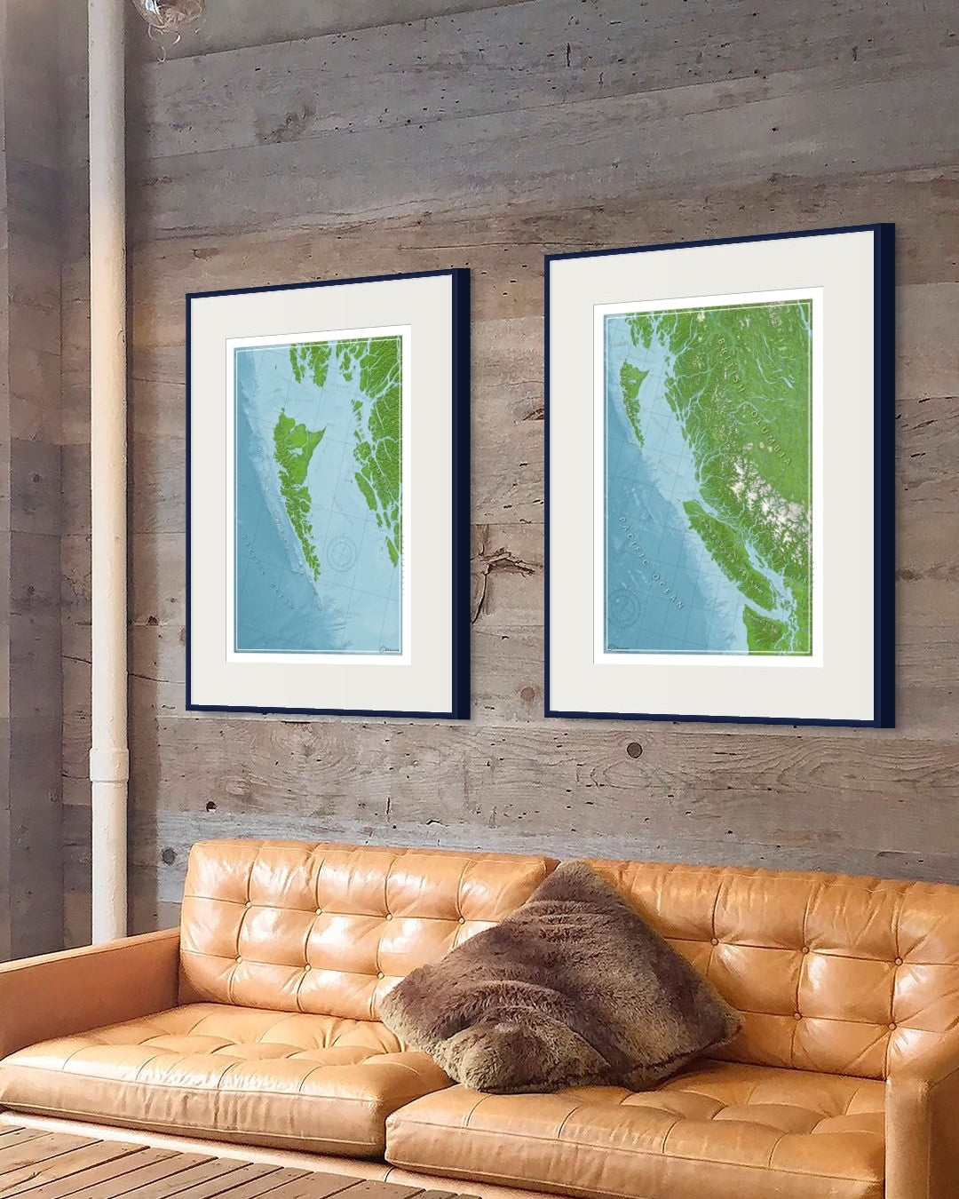 Brown leather sofa with a wooden coffee table against a wooden wall with framed wall art print maps of coastal BC and Haida Gwaii