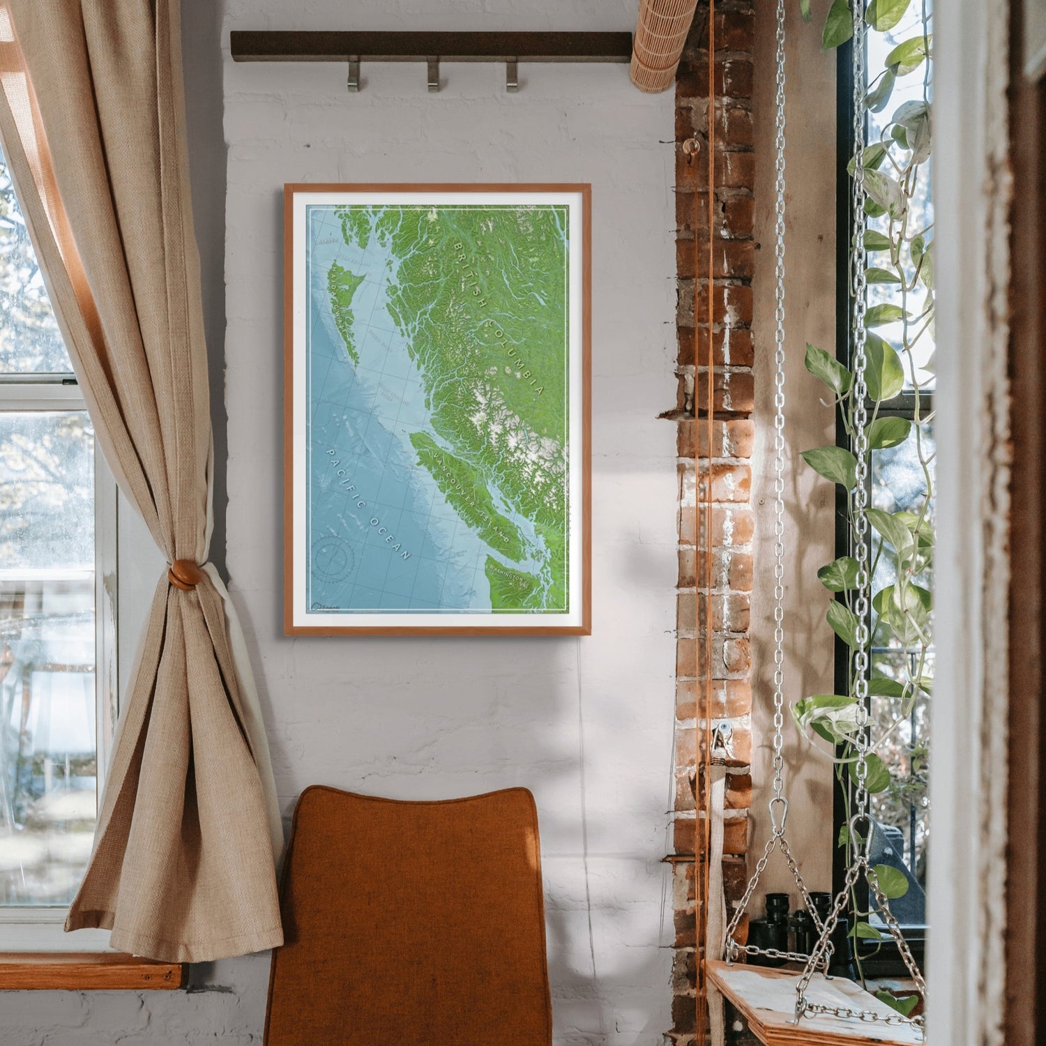 Framed map of a coastal British Columbia, on a wall with a chair and window in the background