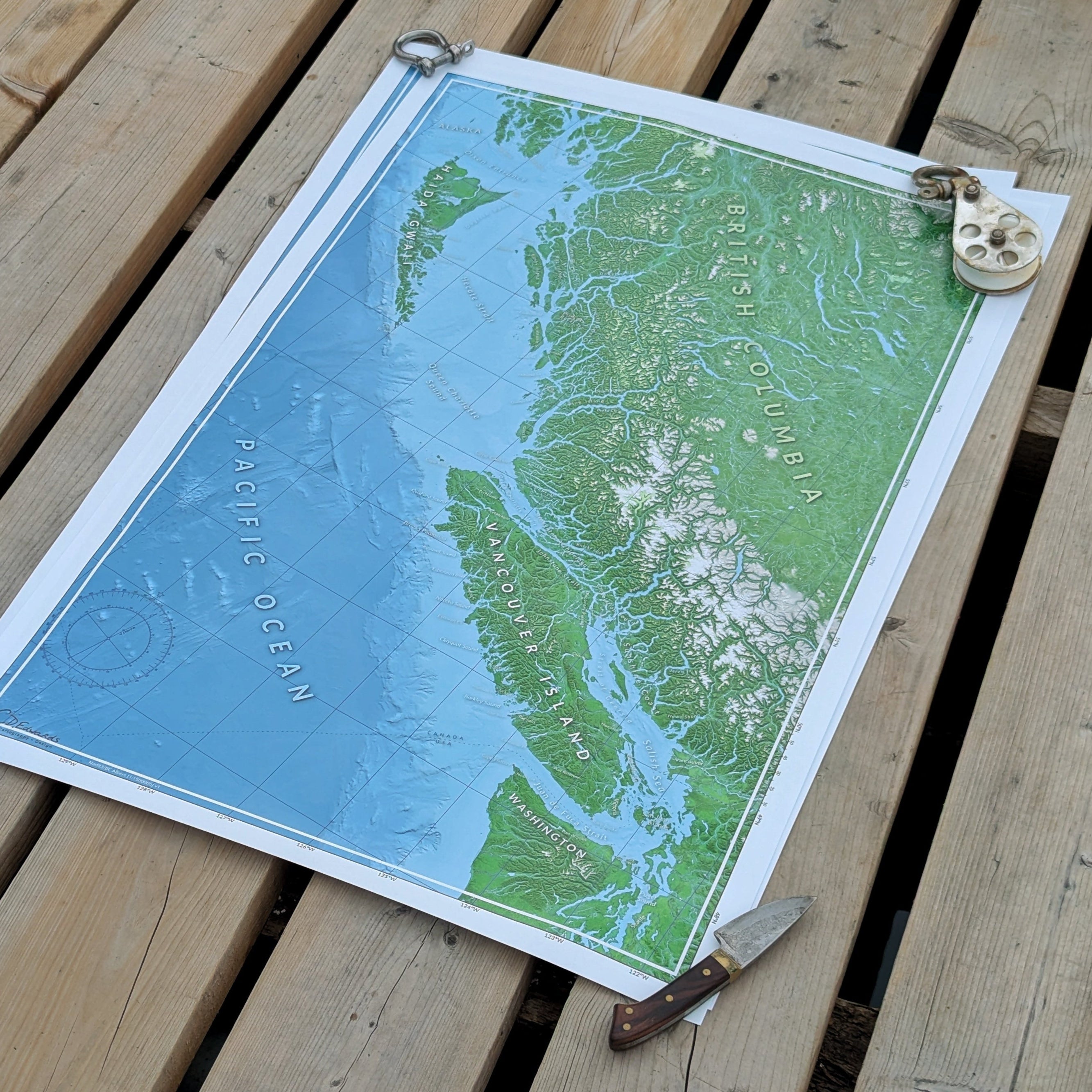 Map of British Columbia on a wooden surface with tools around