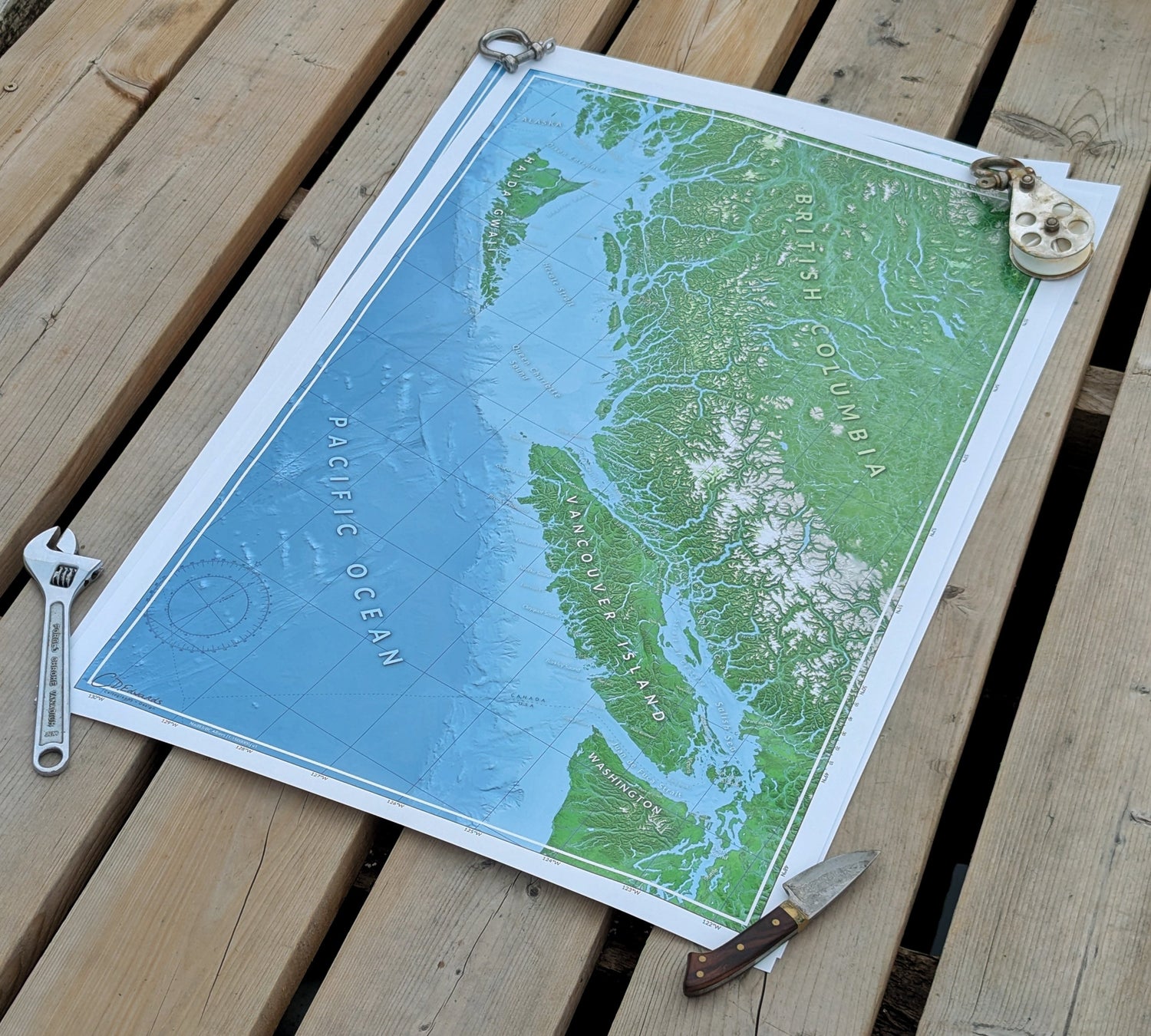 Map of British Columbia on a wooden surface with tools around
